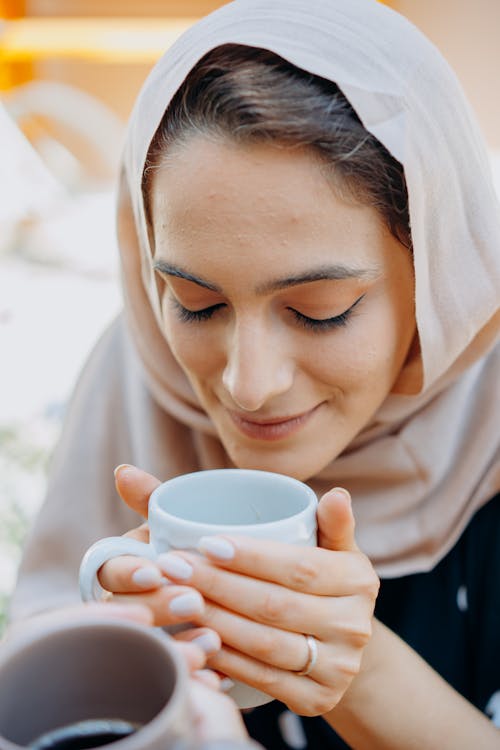 Free Woman in White Hijab Holding White Ceramic Mug Stock Photo