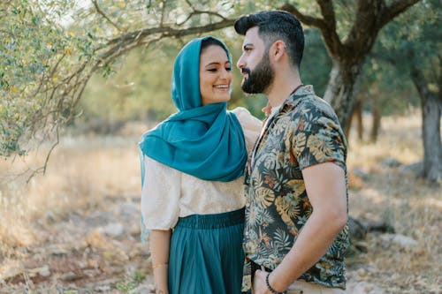 Free Woman Wearing Blue Hijab Looking at a Bearded Man Stock Photo
