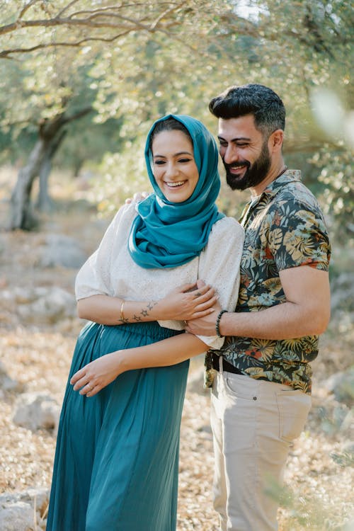 Free Woman Wearing Blue Hijab Standing Beside a Bearded Man Stock Photo