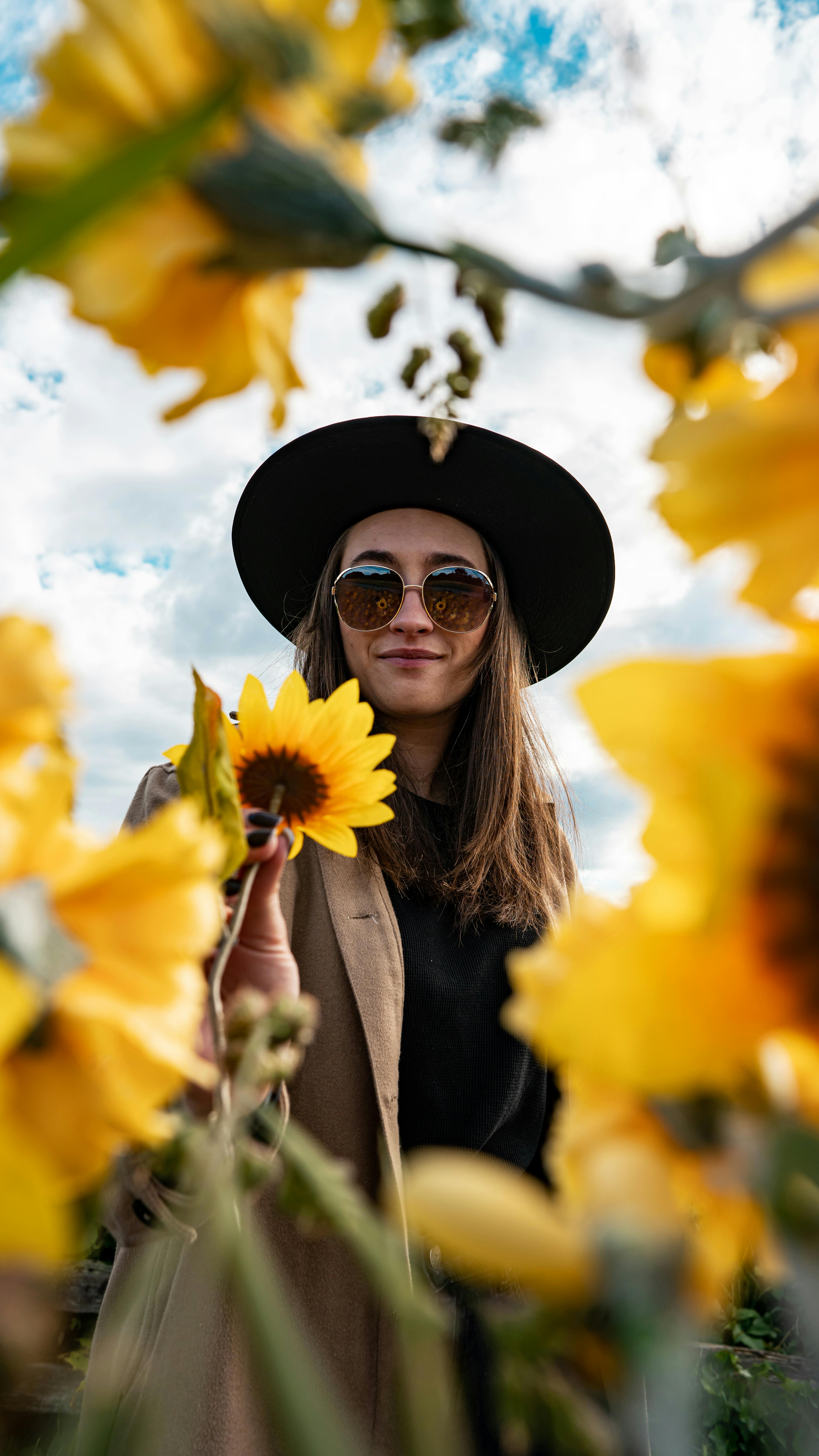 low angle shot of a woman holding a sunflower