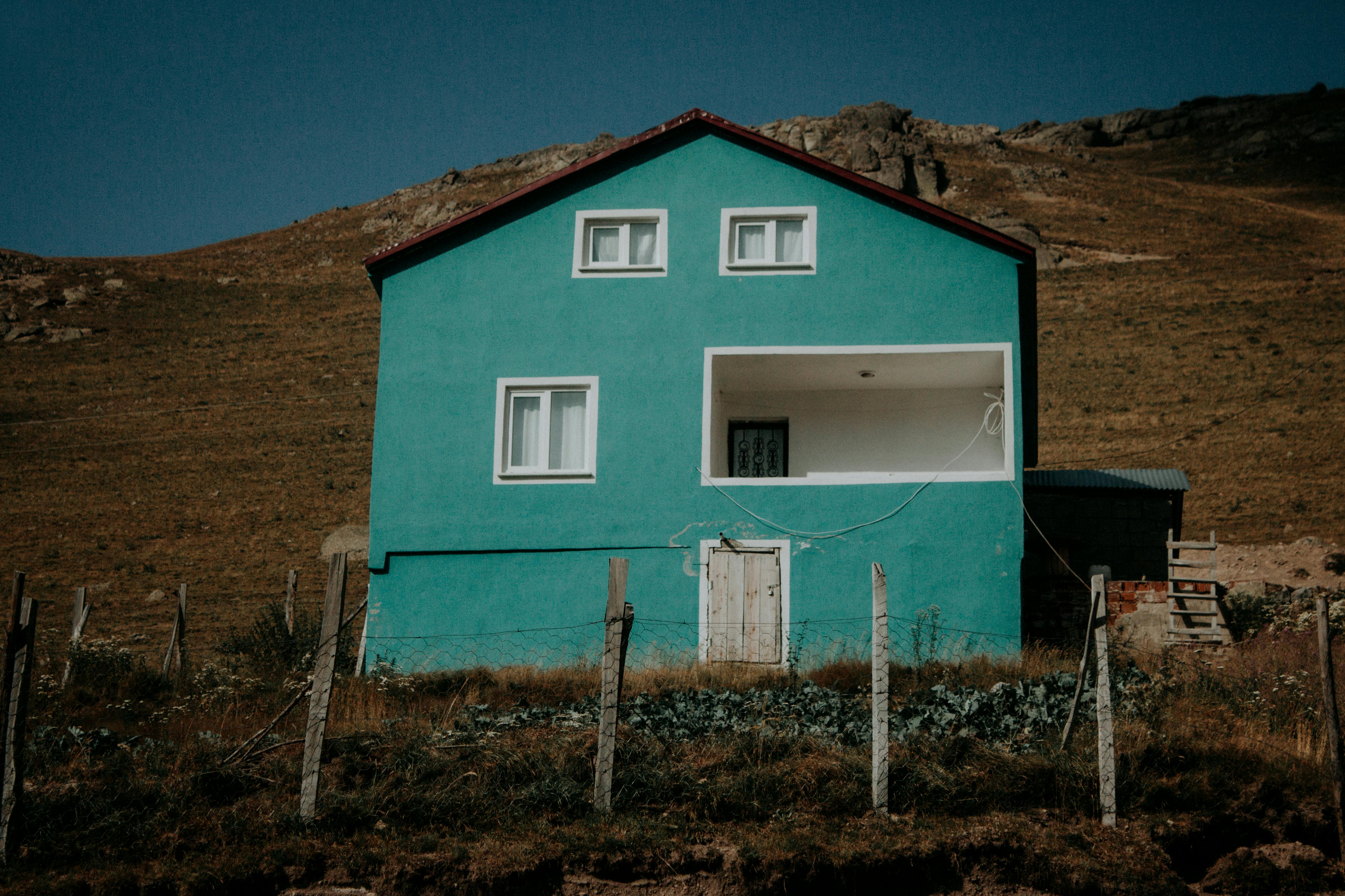 Blue countryside house with white windows and a fence in Giresun, Türkiye.