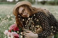 Beautiful Woman Wearing a Dress Looking at Camera and Holding the Flowers