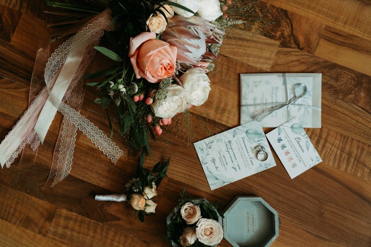 Wedding Invitations Lying On Table By Bouquet Of Flowers