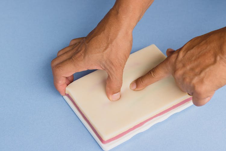 Man Touching An IV Injection Training Pad 