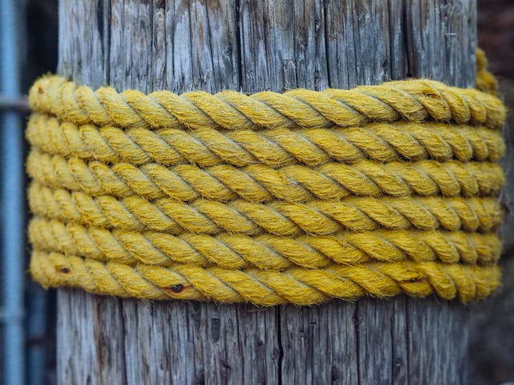 Yellow Rope Wrapped Around A Wooden Post