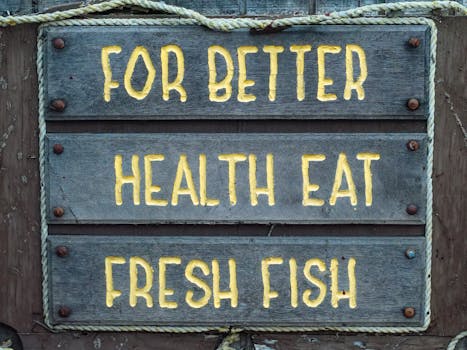 Wooden sign urging better health through fresh fish consumption, set against a rustic background.