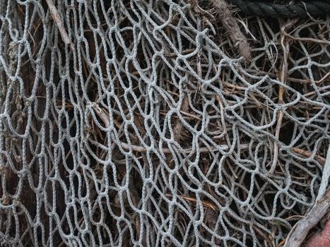 An intricate close-up image showcasing the textures of a rustic fishing net intertwined with ropes.