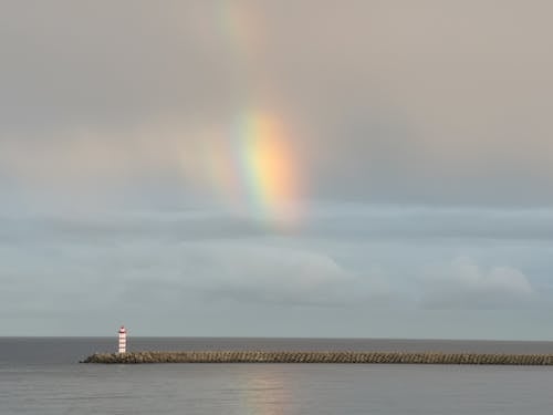 Free Body of Water Under Cloudy Sky with Rainbow Stock Photo