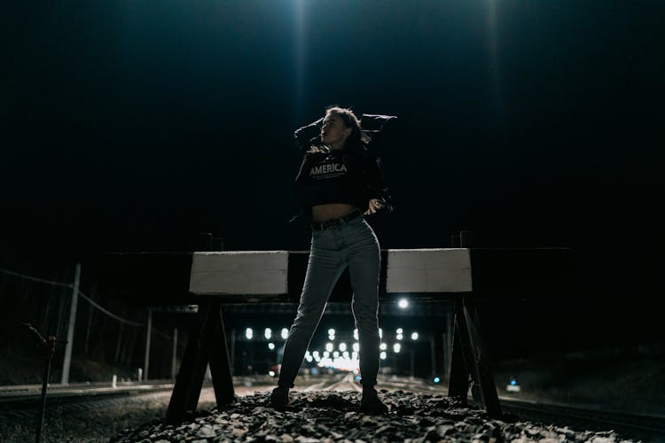 Woman Standing On Train Tracks At Night 