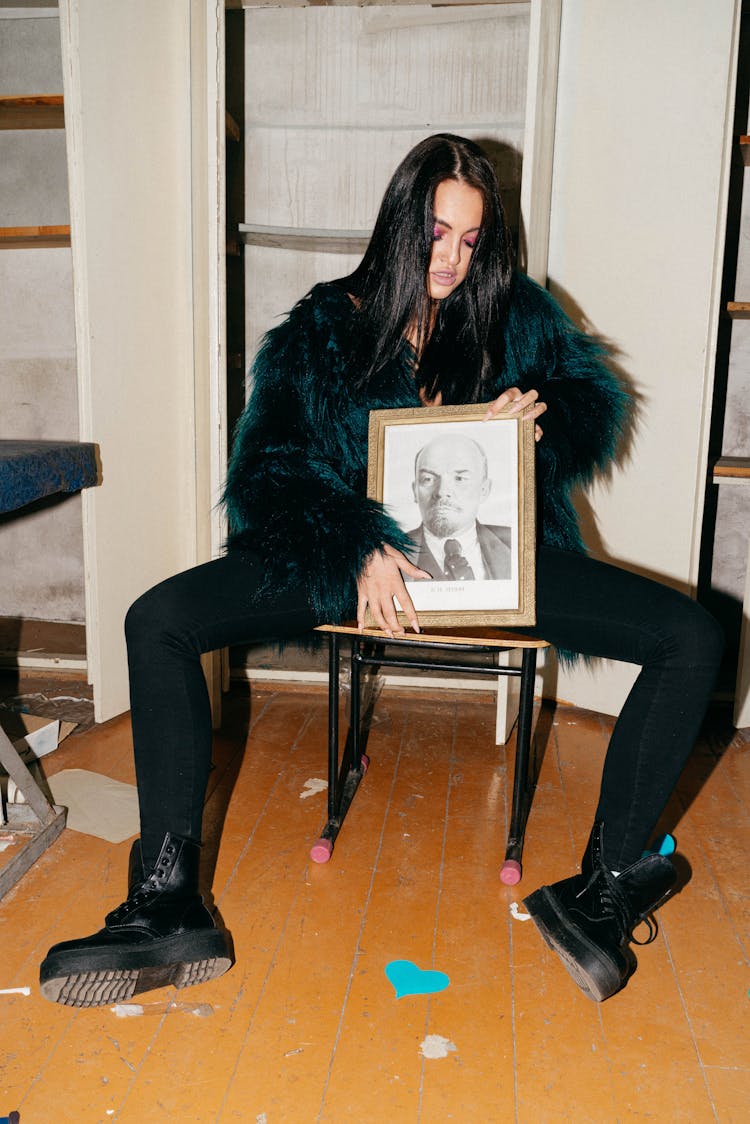 Woman In Black Outfit Holding A Picture Frame 