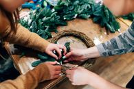 Women Putting Green Garlands on a Ring
