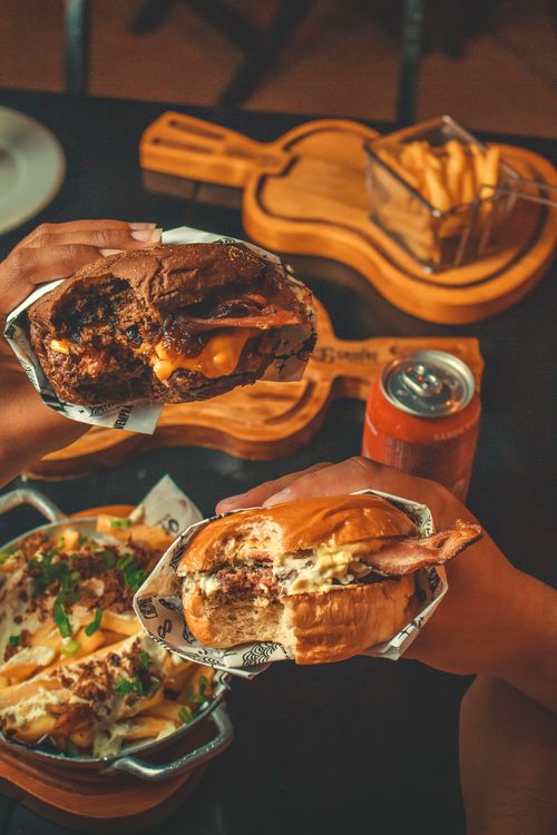 Free Close-up of two cheeseburgers with fries and a drink, creating a delicious fast food experience. Stock Photo