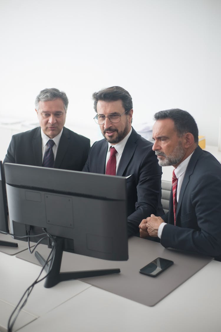 People Looking At A Monitor Inside The Office