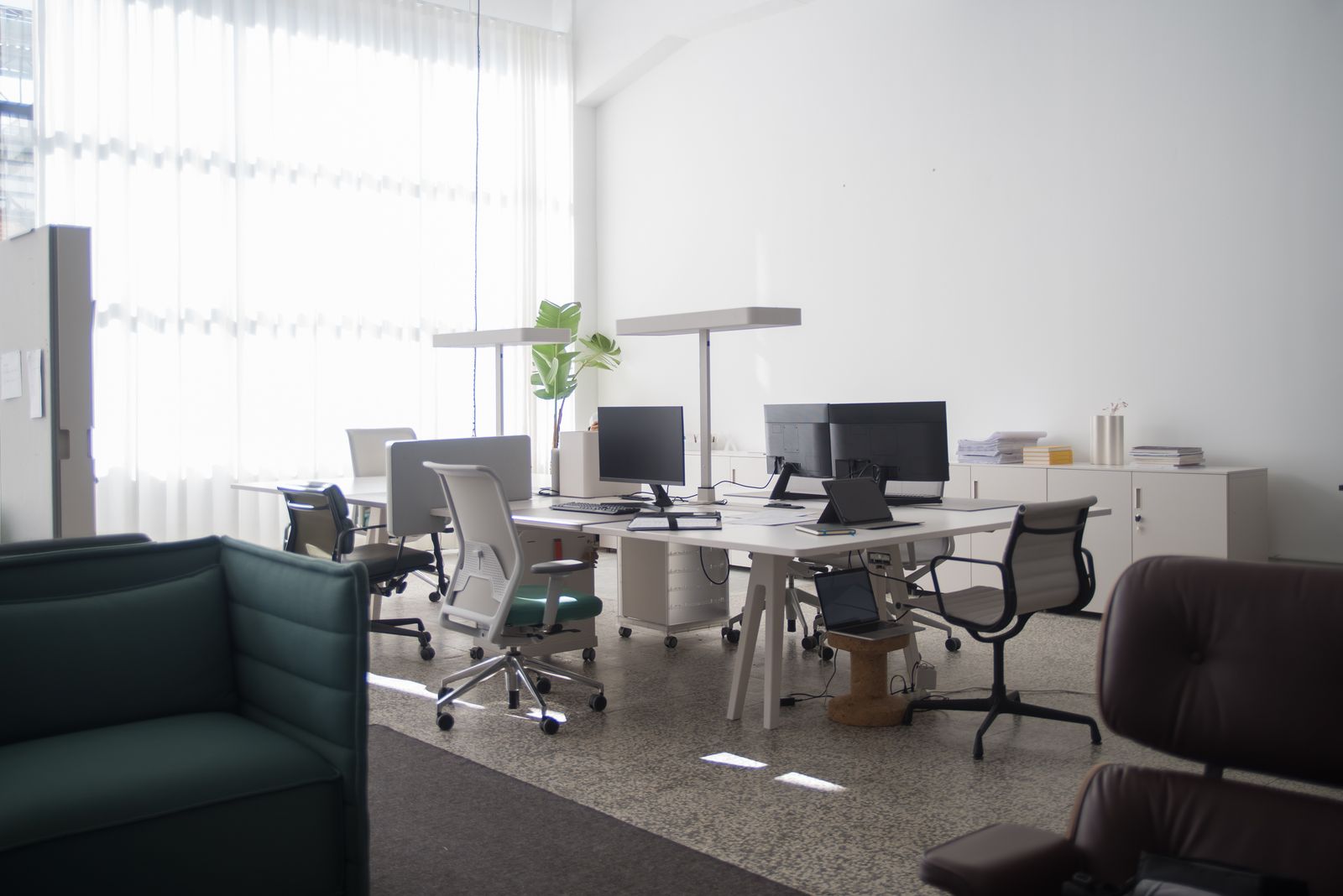The studio floor on a quiet afternoon: shared desks, task chairs and daylight through full-height blinds. Photo by Kampus Production on Pexels.