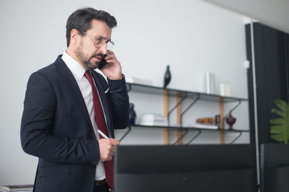 Businessman in a modern office speaking on a mobile phone