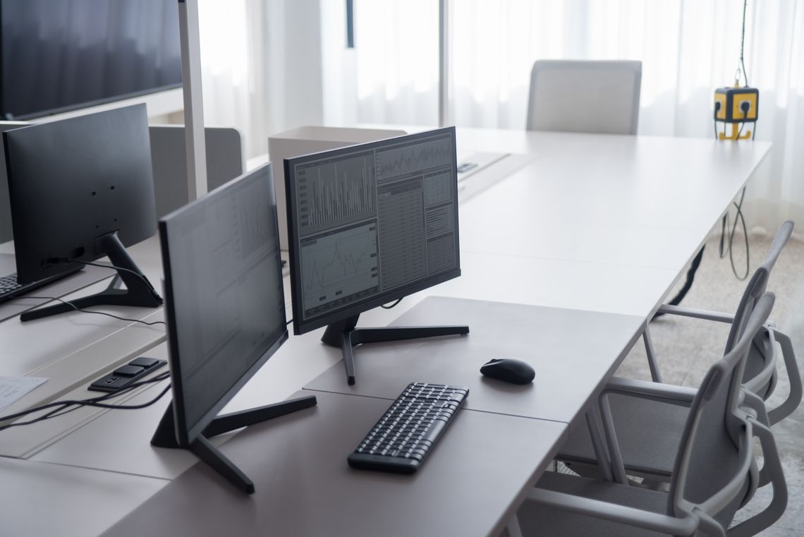 Clean modern office desk with dual monitors and ergonomic seating