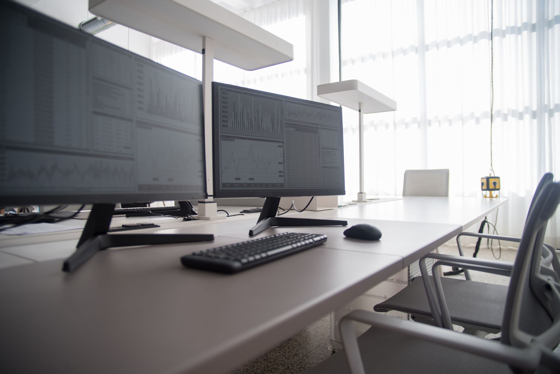 Modern office workspace with multiple monitors showing dashboards