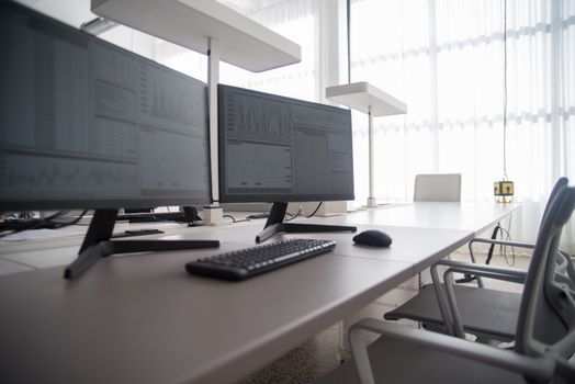 Stylish contemporary office featuring multiple computer monitors and ergonomic chairs.