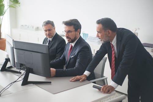 Three Men in Black Suit Looking At Computer Screen