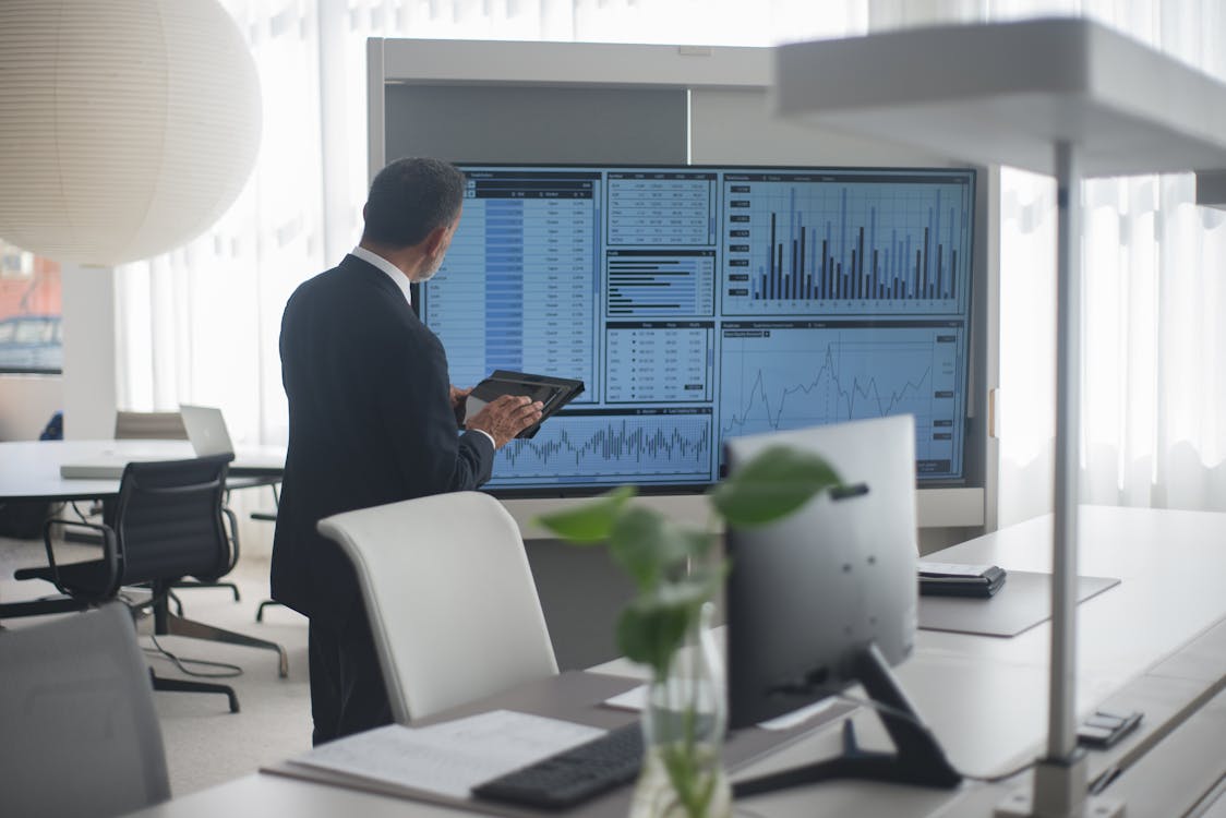 Free Man Looking At A Screen With Stock Market Data Stock Photo