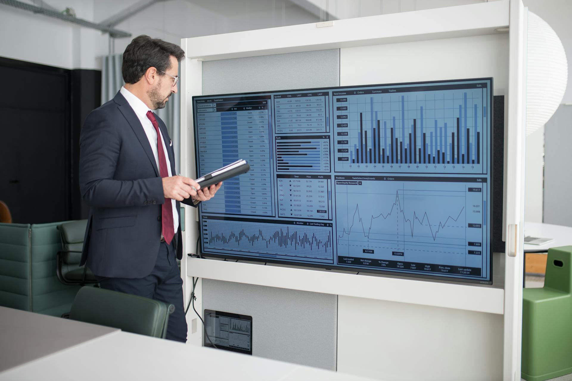 Man in Corporate Attire Looking at a Wide Screen Monitor