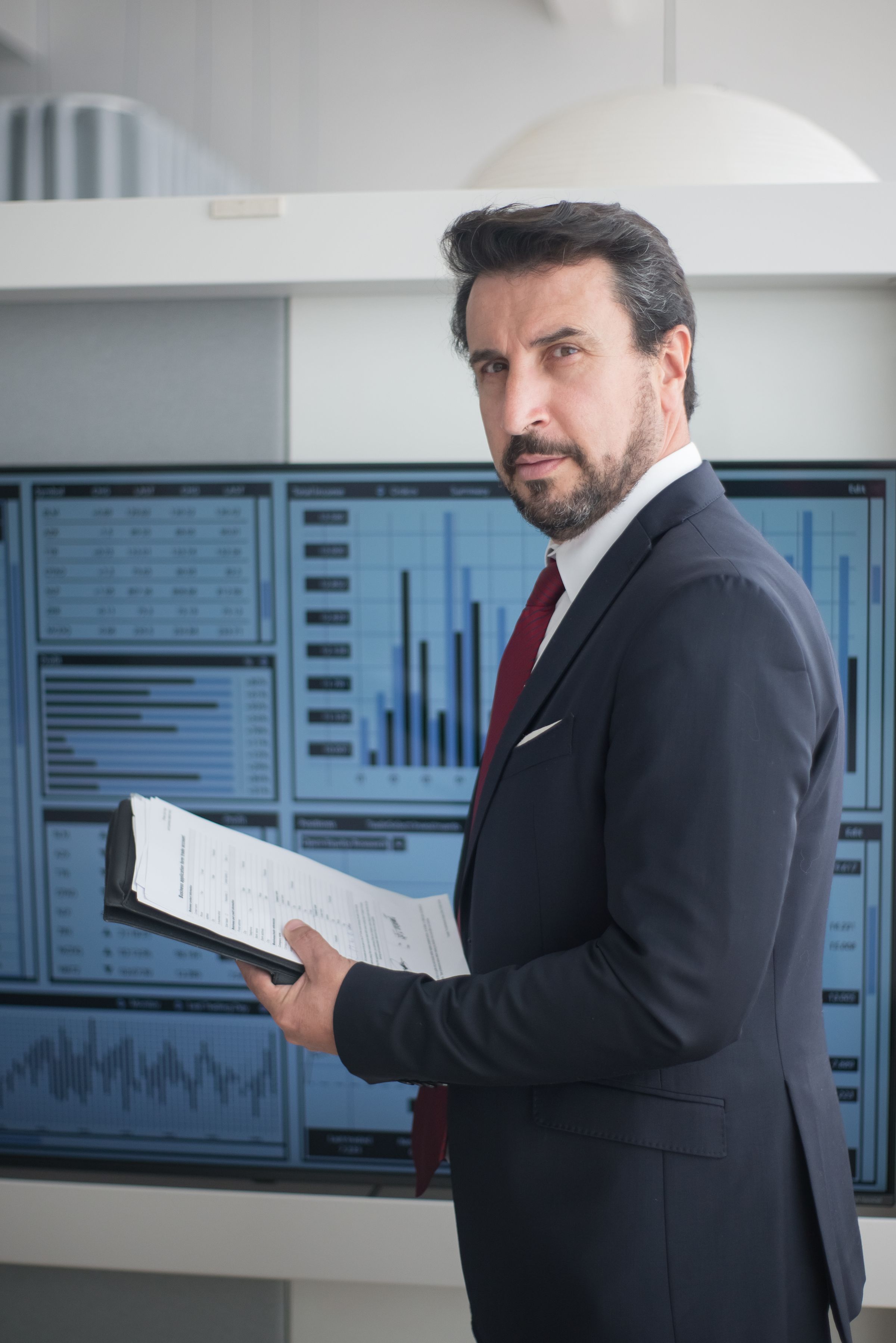 Financial professional analysing live financial information across digital screens.