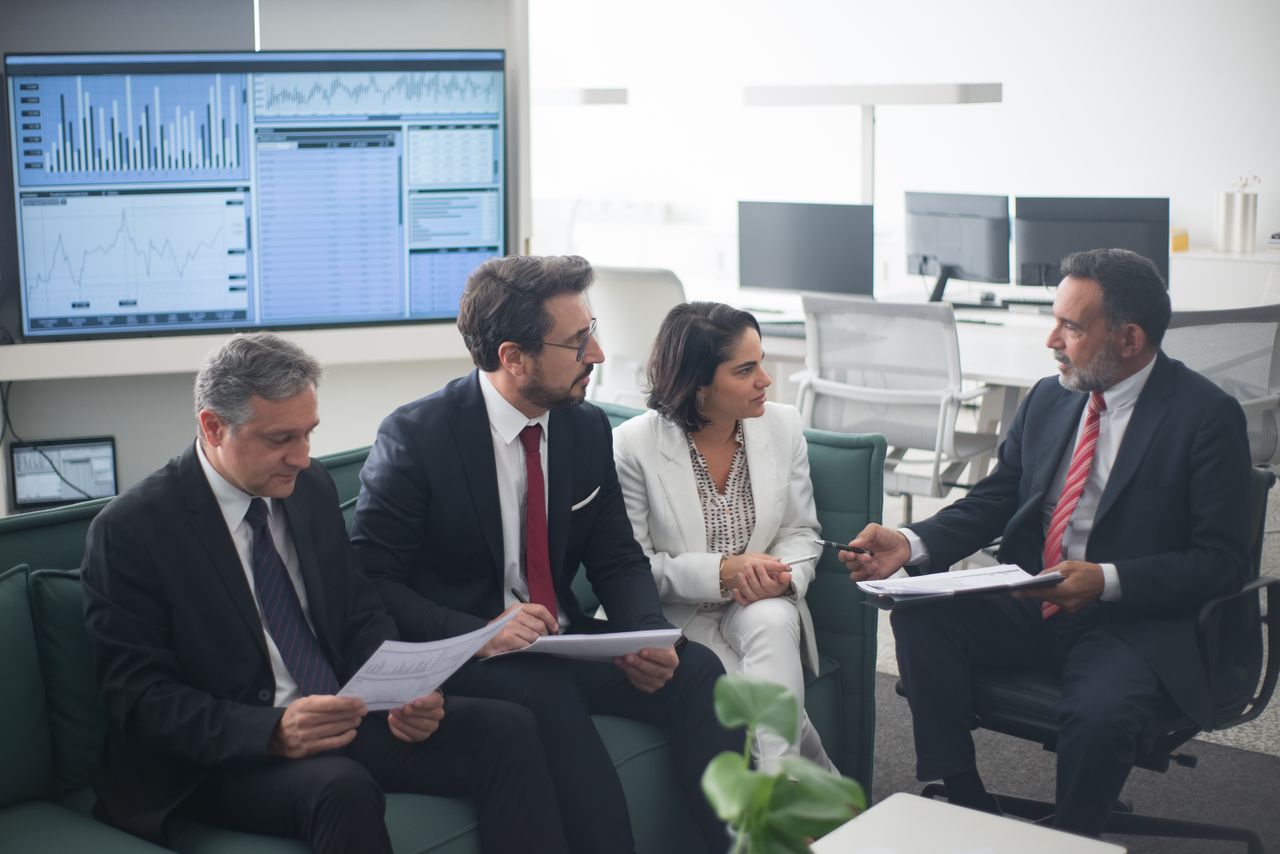 Group of business professionals discussing financial strategies in a modern office setting