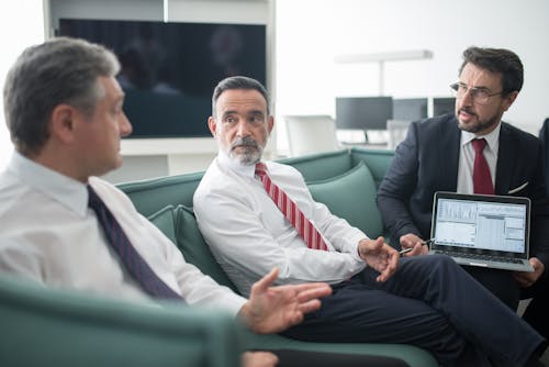 Men Sitting on Sofa at the Office While Having a Conversation