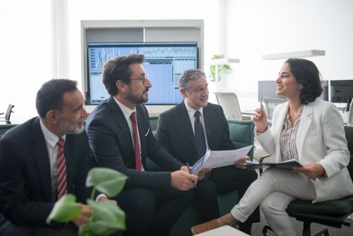 Free Diverse business professionals engaged in a lively office meeting, fostering collaboration and teamwork. Stock Photo