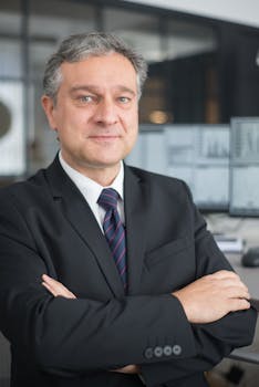 Corporate professional with arms crossed in modern office, symbolizing leadership and confidence.