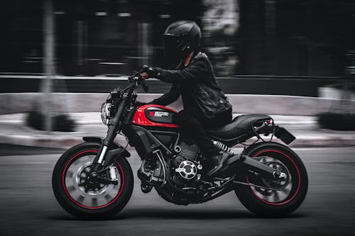 Man in Black Leather Jacket Riding Black and Red Motorcycle