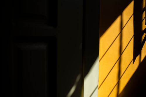 Free Abstract shadows of railings create patterns on a yellow wall, showcasing contrast and design. Stock Photo