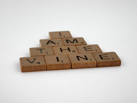 Scrabble tiles spelling 'I Am The Vine' arranged in a pyramid on a white background.