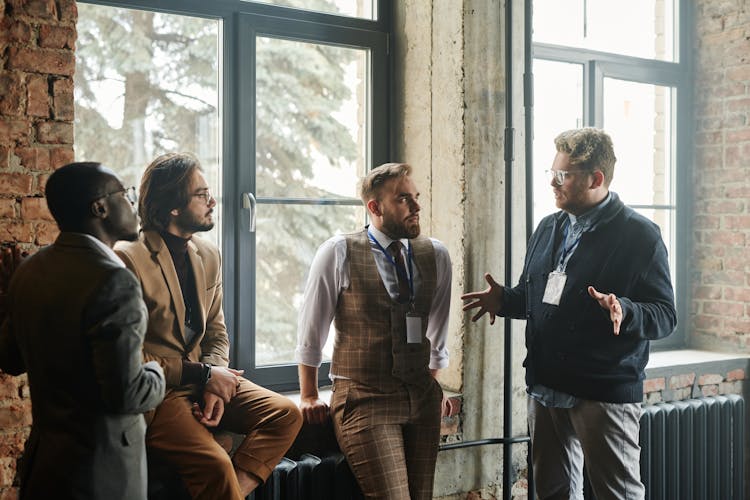 A Group Of Men Having Conversation Near The Glass WIndows