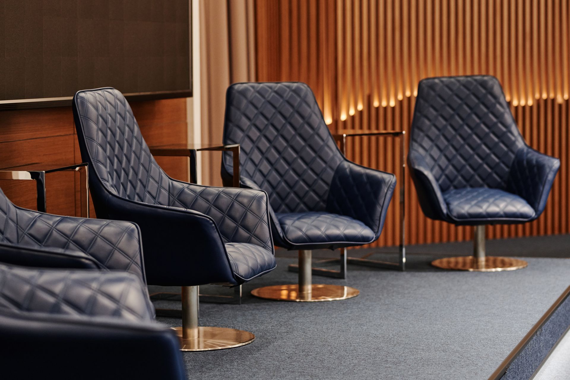 Elegant empty conference room with stylish blue leather chairs and wooden paneling.