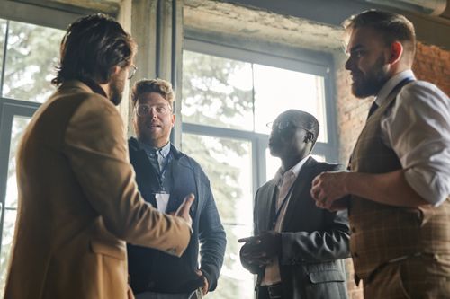 Free Group of men having a collaborative business meeting indoors with window views. Stock Photo