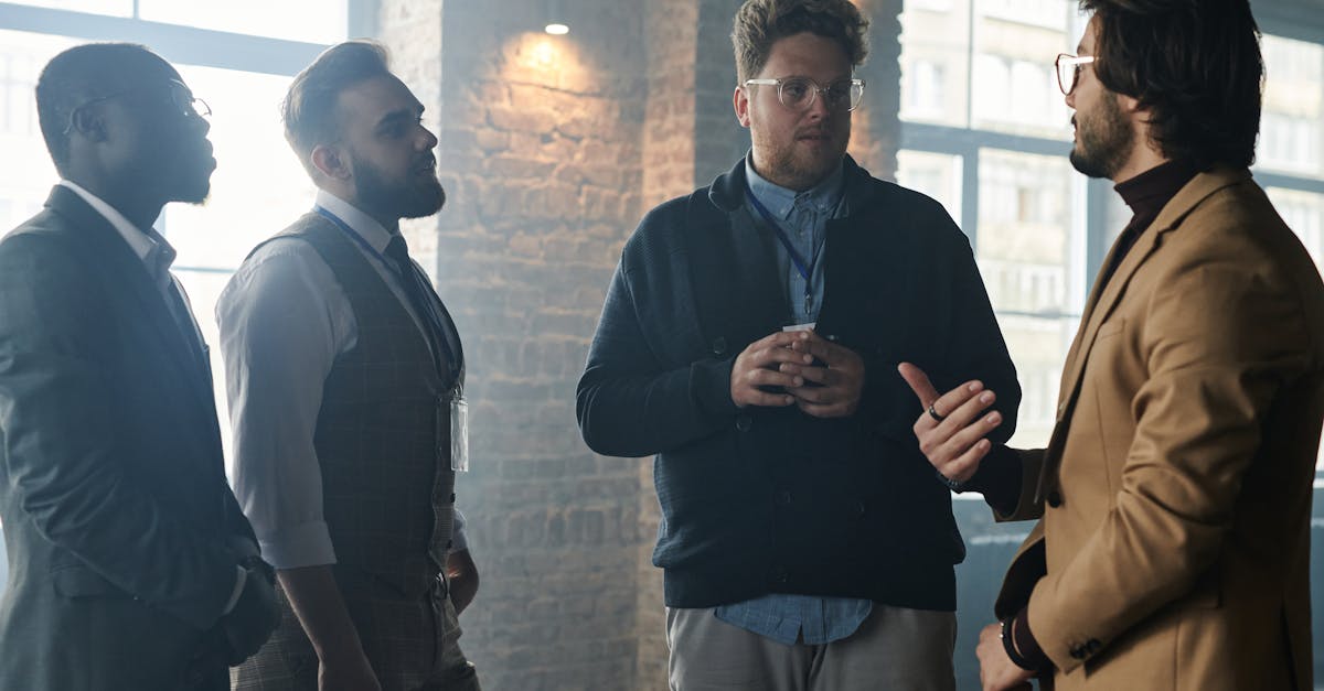 Photo by Henri Mathieu-Saint-Laurent A group of diverse young professionals in business attire having a focused discussion indoors.