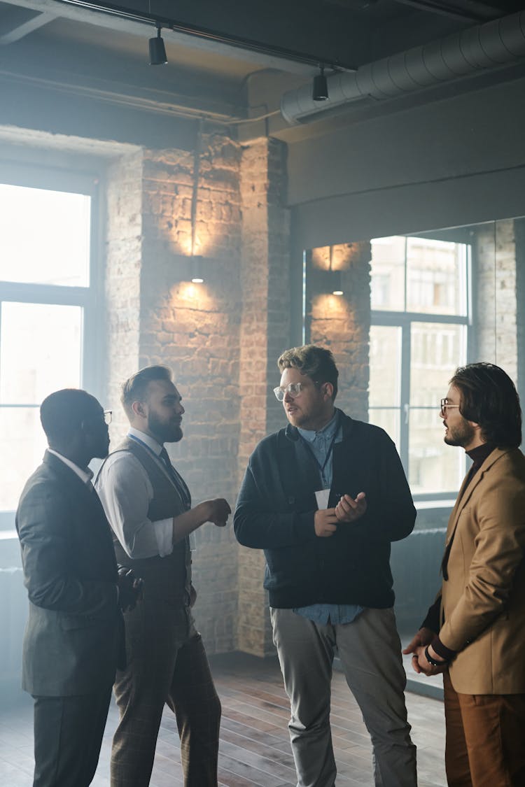 A Group Of Men Standing While Having Conversation