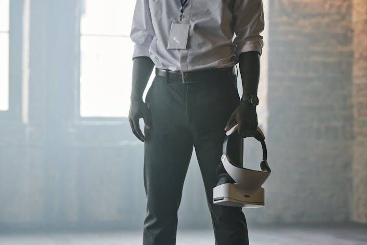 A Person In Corporate Attire Holding VR Goggles