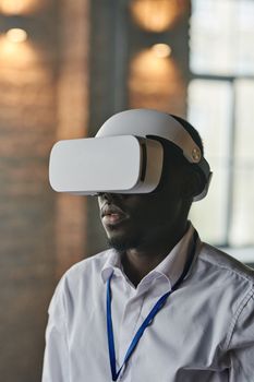A businessman immersed in virtual reality through a headset in an office setting.