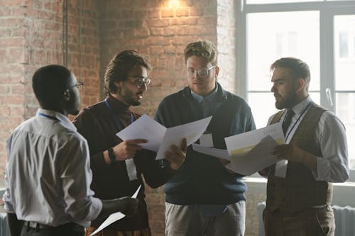 A Group of Men Holding Papers 