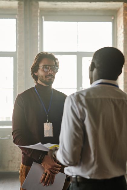 Two colleagues in conversation by a window, photo by Henri Mathieu-Saint-Laurent on Pexels