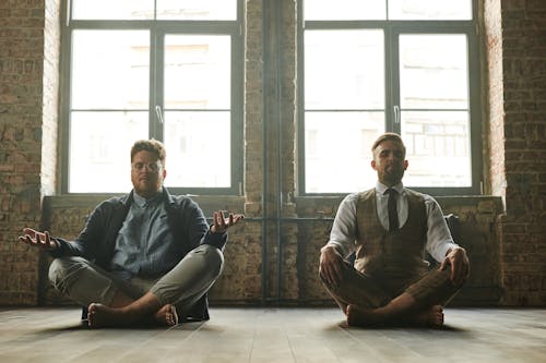 Men Sitting on the Floor While Meditating 
