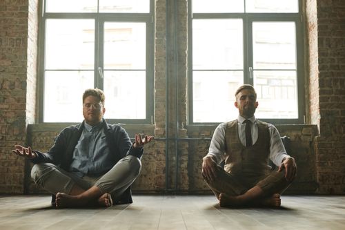Free Two men meditating indoors in a loft with natural light, promoting relaxation and mindfulness. Stock Photo