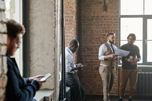 Free A diverse group of coworkers discuss ideas in a stylish urban office setting. Stock Photo