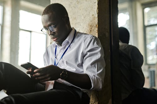 Man Sitting while Using Cellphone