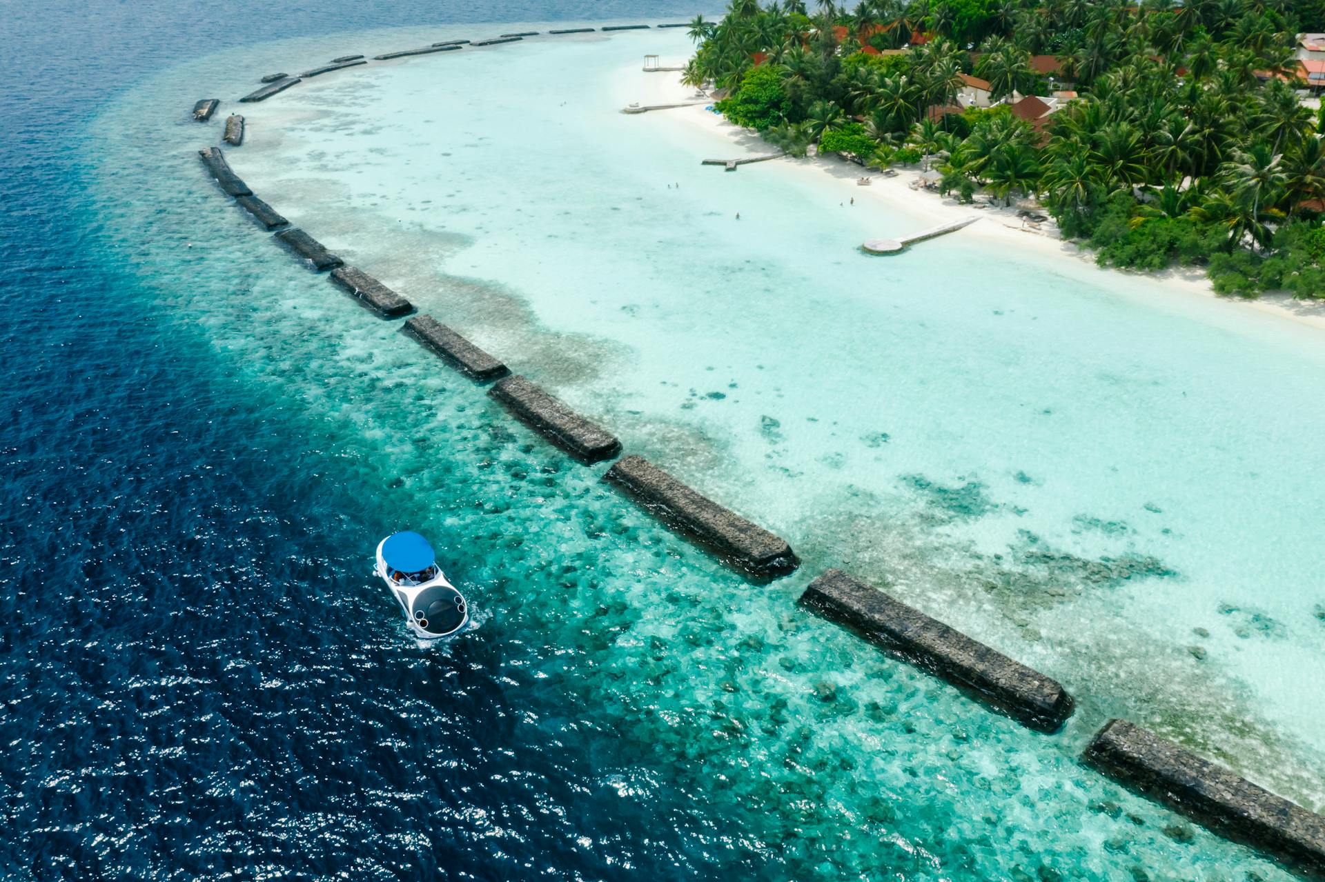 Stunning aerial view of a tropical island resort with turquoise waters and white sand beaches.
