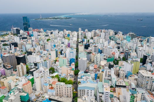 Vibrant aerial view of a bustling city skyline with an ocean backdrop.