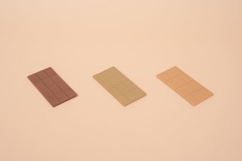 Free Three chocolate bars on a beige background showcasing a minimalist and clean design. Stock Photo