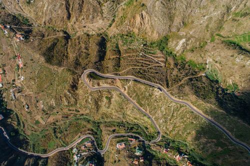 Free A stunning aerial view showcasing a winding road through a mountainous landscape. Stock Photo